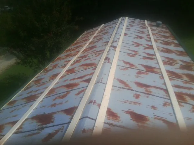 Rusted metal roof panels with new wood purlins before replacement — Storm Damage Roof Repair in Mabelvale by Roofing Brothers
