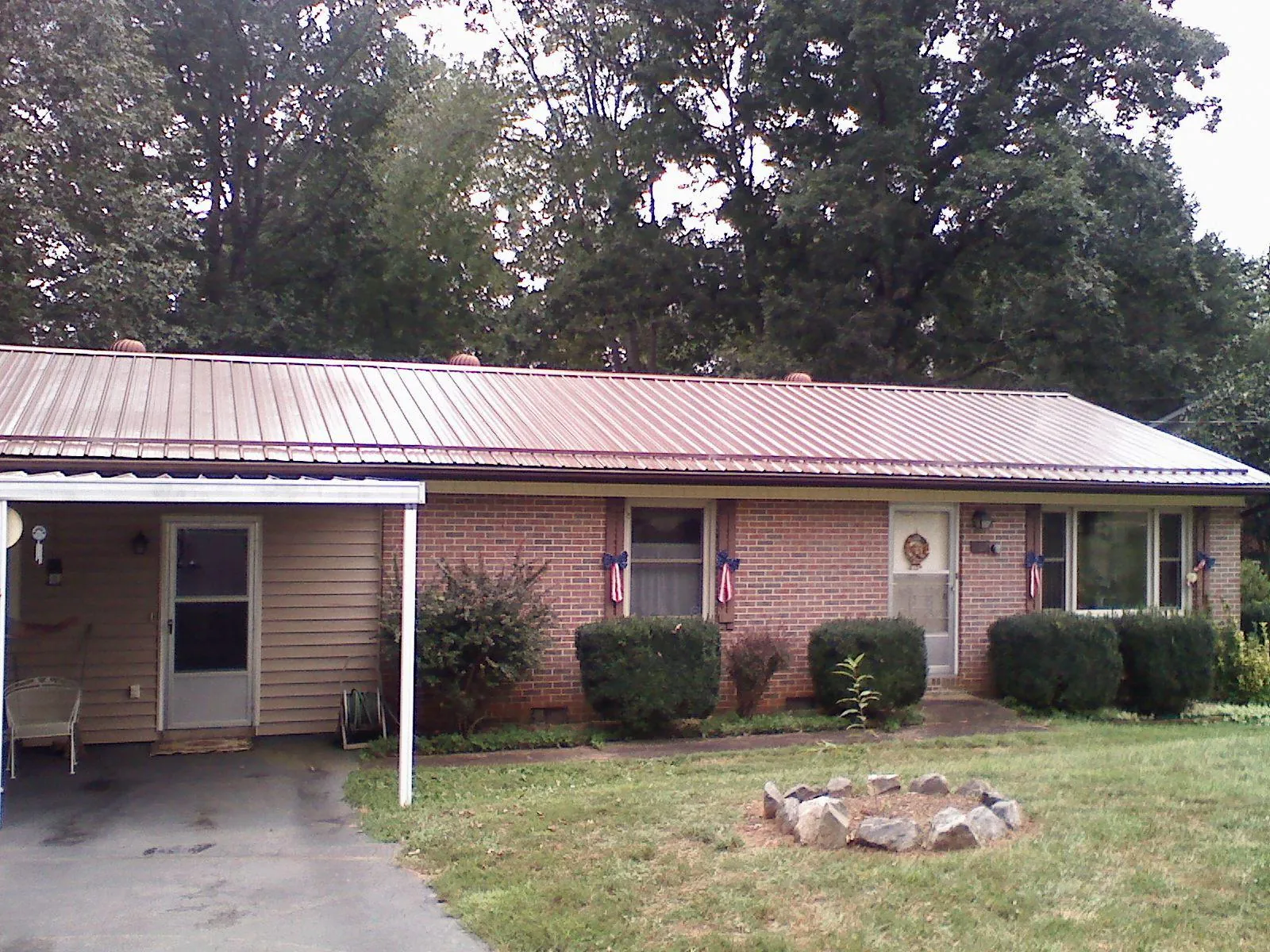 Bronze metal roof and carport on a brick ranch home — Roof Repair work by our crew in Mabelvale