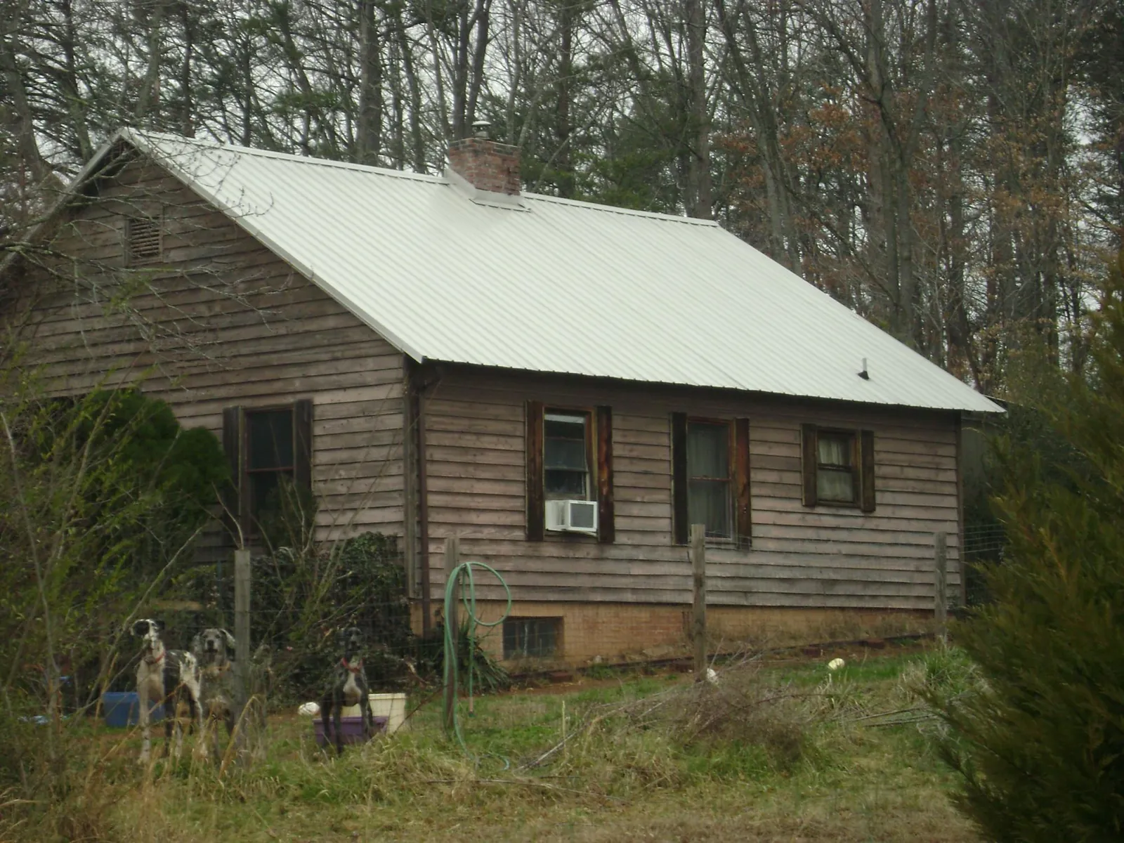 White metal roof on an old wood sided farmhouse, from a Metal Roof Installation job in Mabelvale